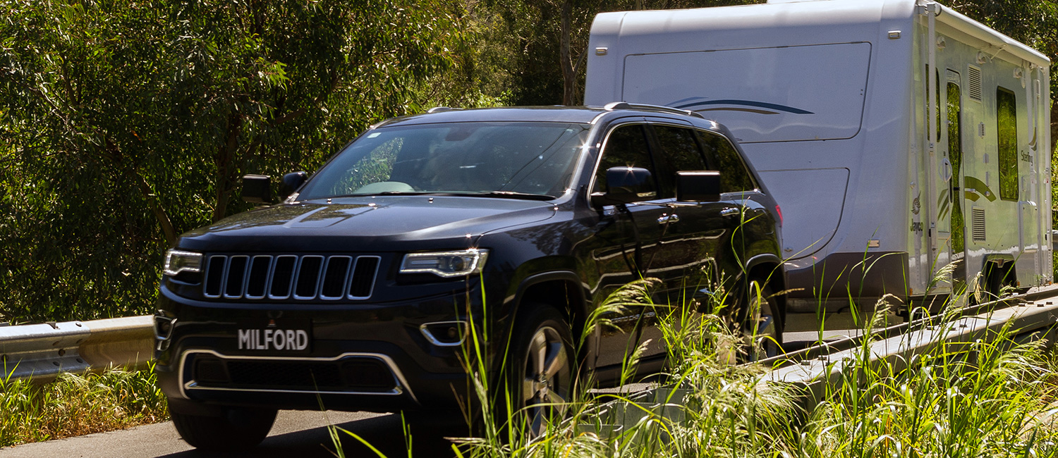 Vehicle Towing Caravan Along Road